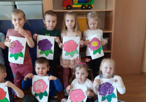Zosia, Jaś, Kornelia, Nikola, Martynka, Blanka i Adaś prezentują swoje obrazki róż.